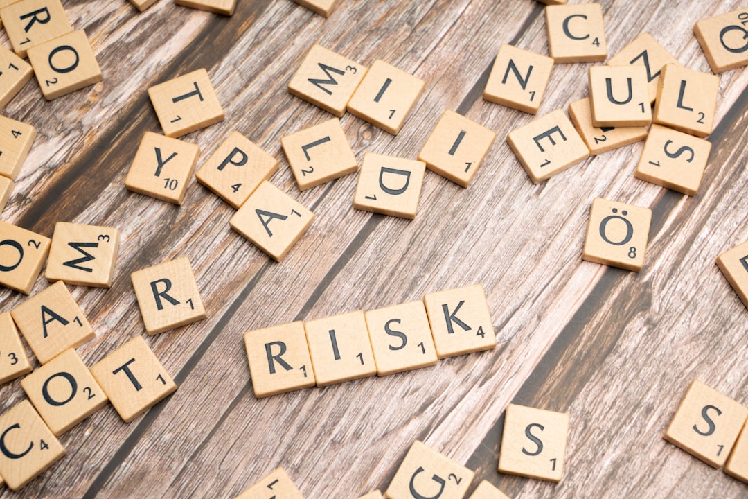Scrabble-Steine auf Holz, die das Wort RISK bilden